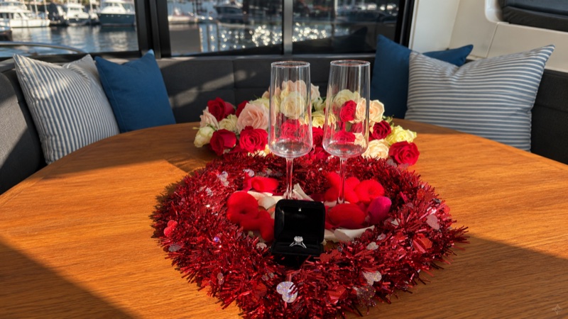 Engagement ring and roses set up for a proposal aboard Luna Cat