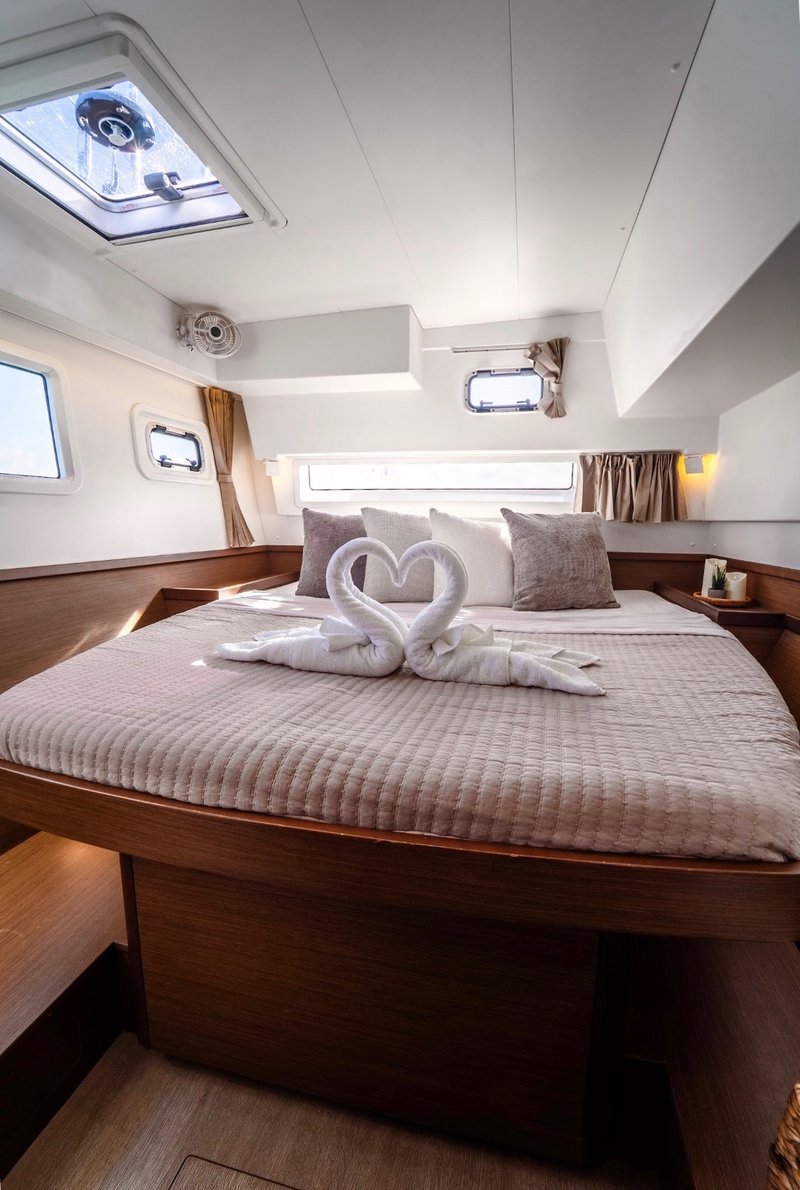 Romantic cabin setup aboard LunaCat — swan towels and rose petals